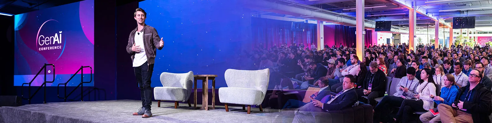 Austin Distel speaking on stage at an AI conference